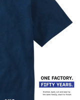 A close-up of a navy blue short-sleeve knit garment on a white background, with printed text reading 'ONE FACTORY. FIFTY YEARS.