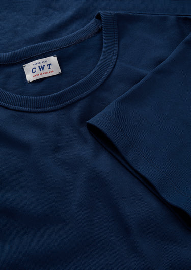 Close-up of a blue t-shirt with a label on the collar.