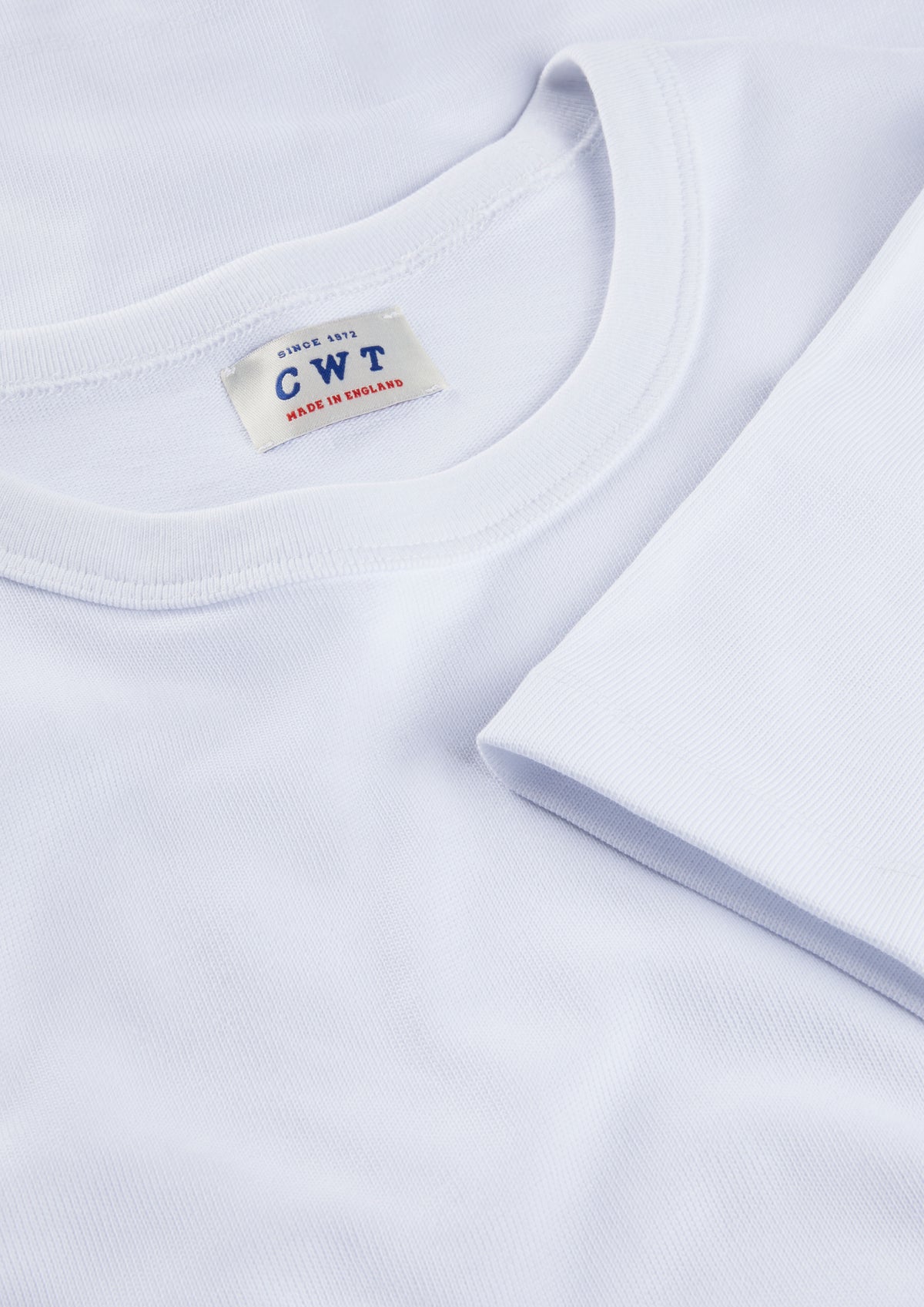 Close-up of a white t-shirt with a label on a light gray background