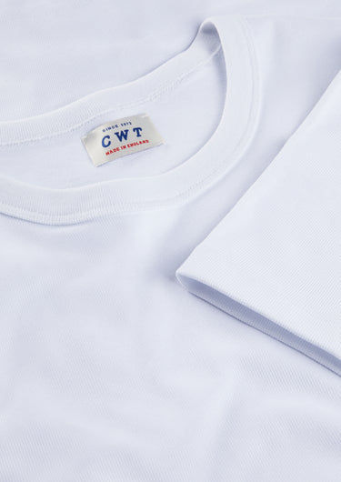 Close-up of a white t-shirt with a label on a light gray background
