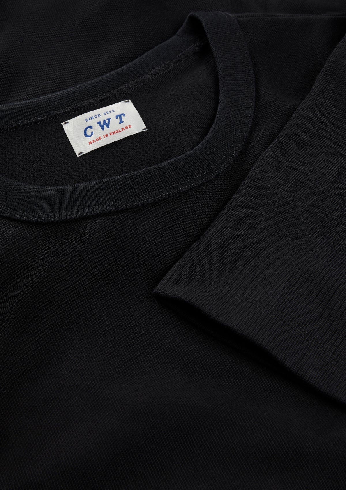 Black t-shirt with a visible brand label on a dark background