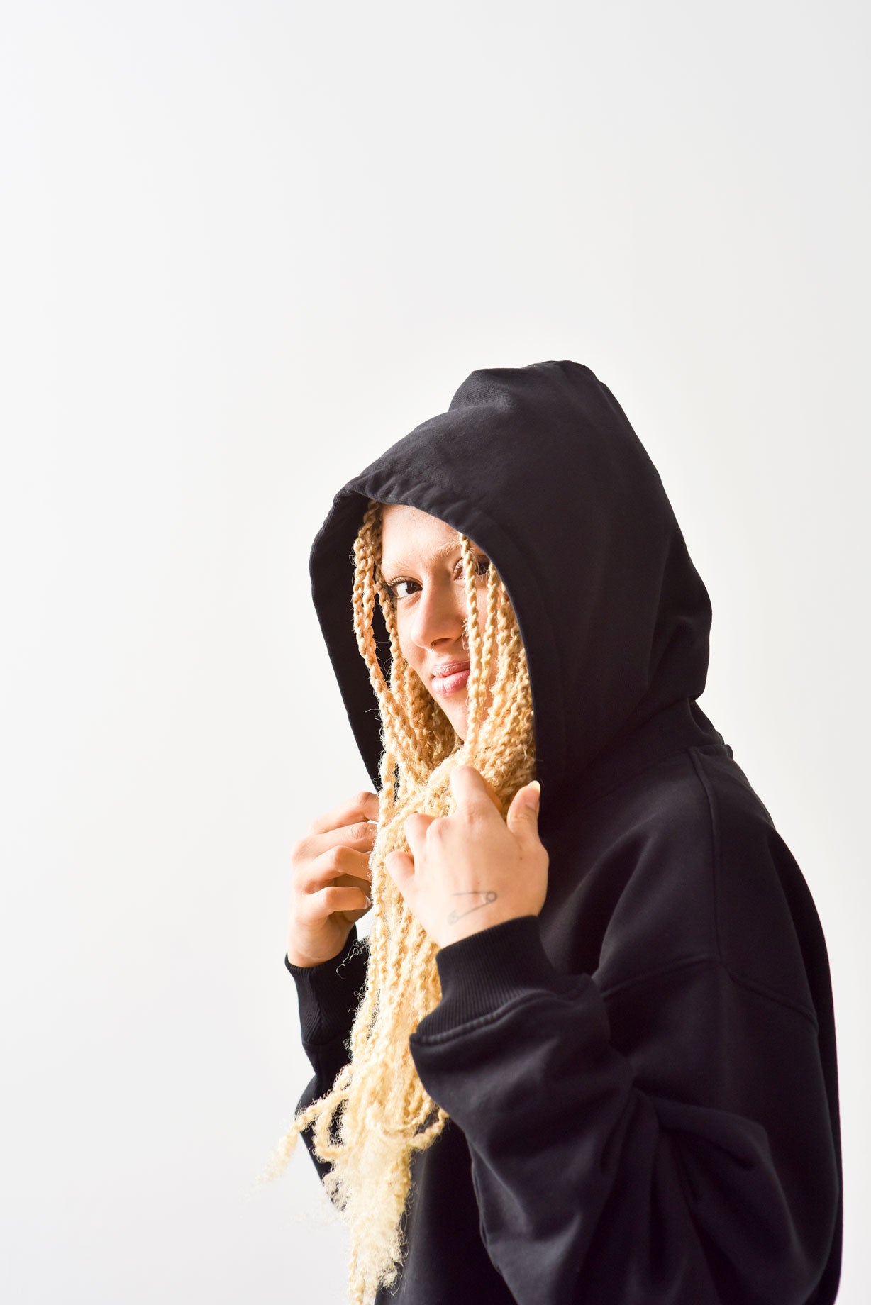 female ith hood up in black hoodie.